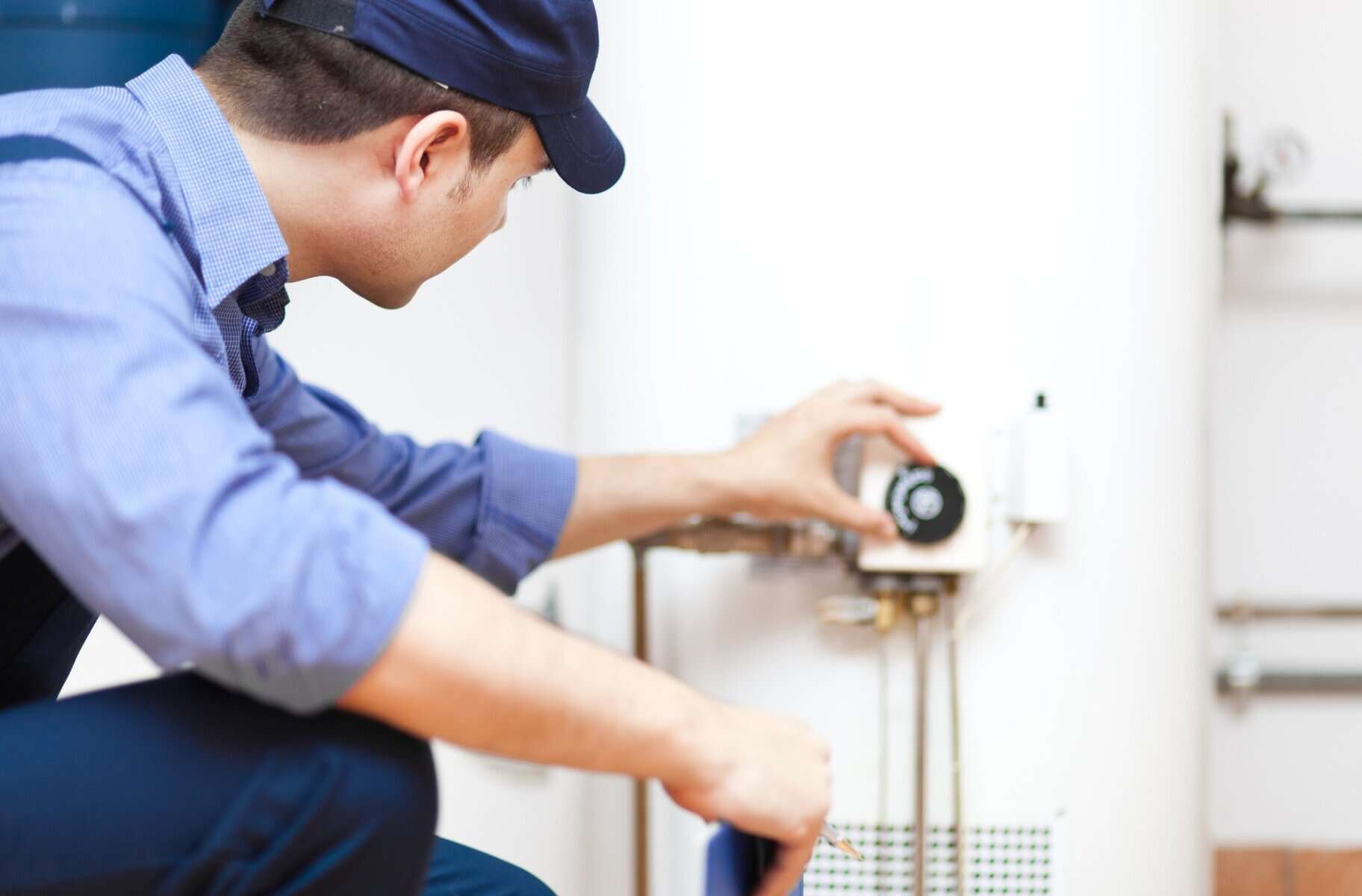 High-quality HVAC technician working on home heating system, professional plumbing and air conditioning repair service, licensed and insured HVAC and plumbing technician.