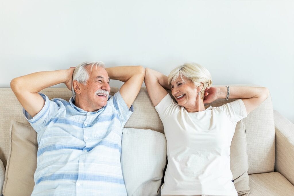 Relaxed senior couple enjoying a conversation at home, highlighting trusted HVAC and plumbing services for homeowners.