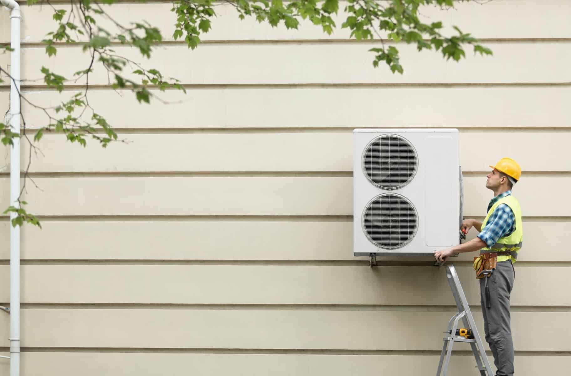 Expert HVAC technician inspecting air conditioning unit outside house, emphasizing top-rated HVAC and plumbing services for home comfort.