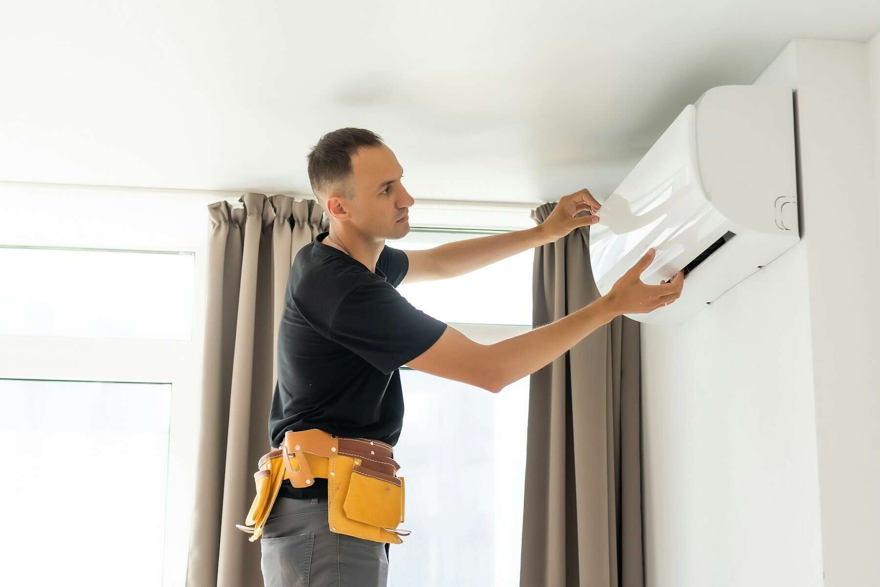 Efficient HVAC technician installing or repairing air conditioning unit for optimal home climate control, emphasizing top-rated HVAC services.